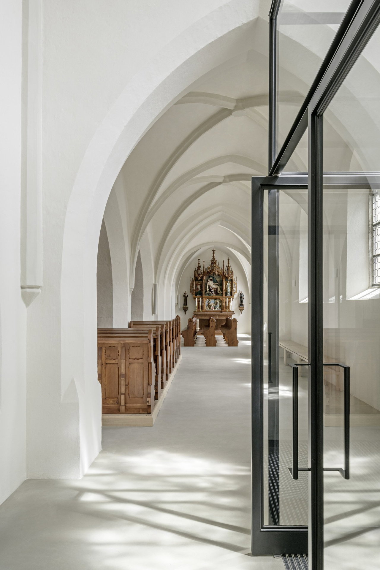 Pivottür aus Stahl und Glas in einem Sakralbau in Oberneukirchen mit FritsJurgens System M Pivot-Scharniersystem im Inneren