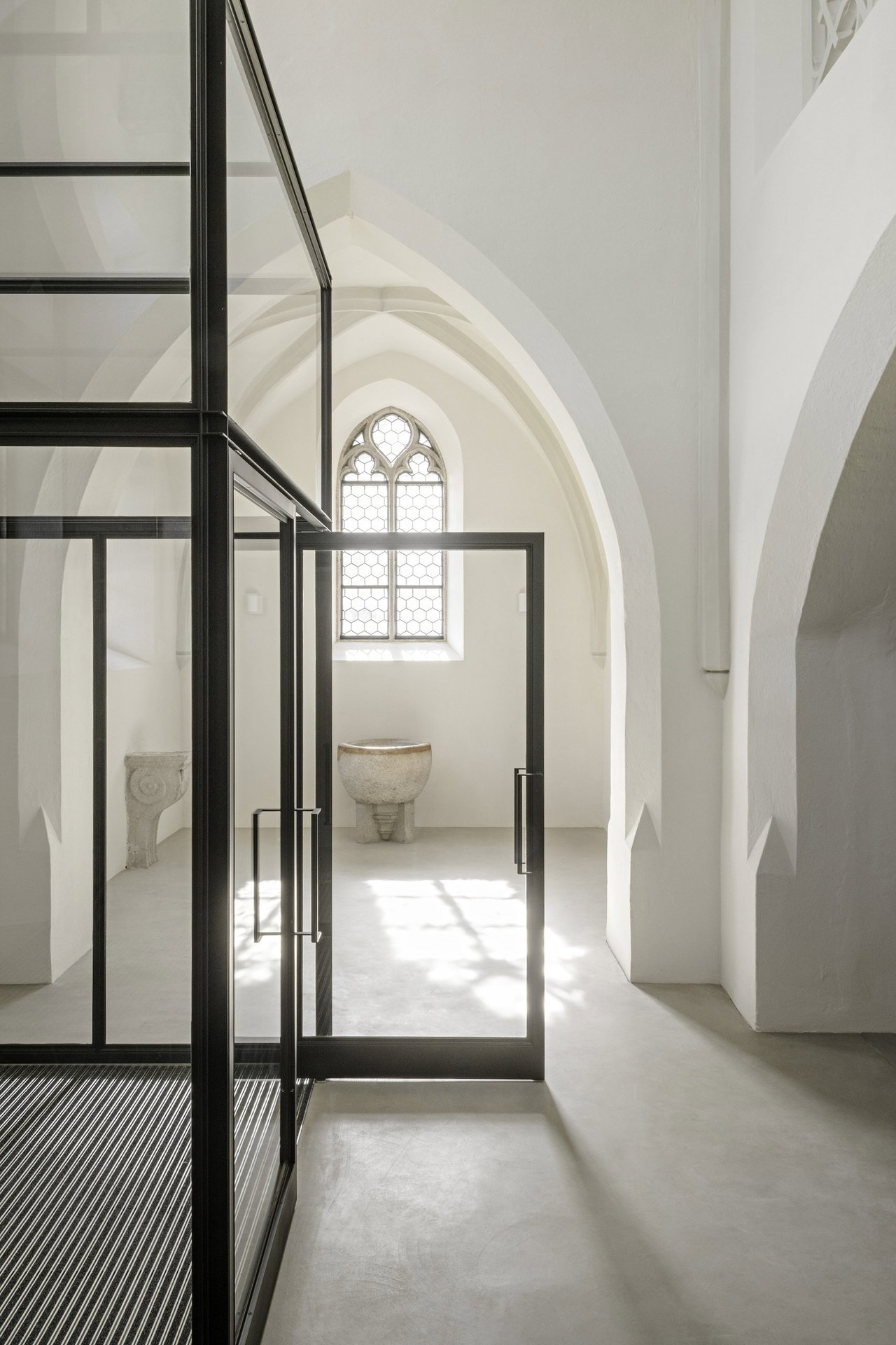 Pivottür aus Stahl und Glas in einem Sakralbau in Oberneukirchen mit FritsJurgens System M Pivot-Scharniersystem im Inneren