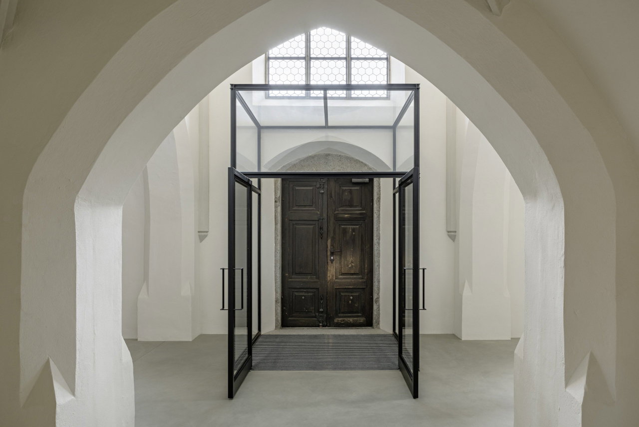 Pivottür aus Stahl und Glas in einem Sakralbau in Oberneukirchen mit FritsJurgens System M Pivot-Scharniersystem im Inneren
