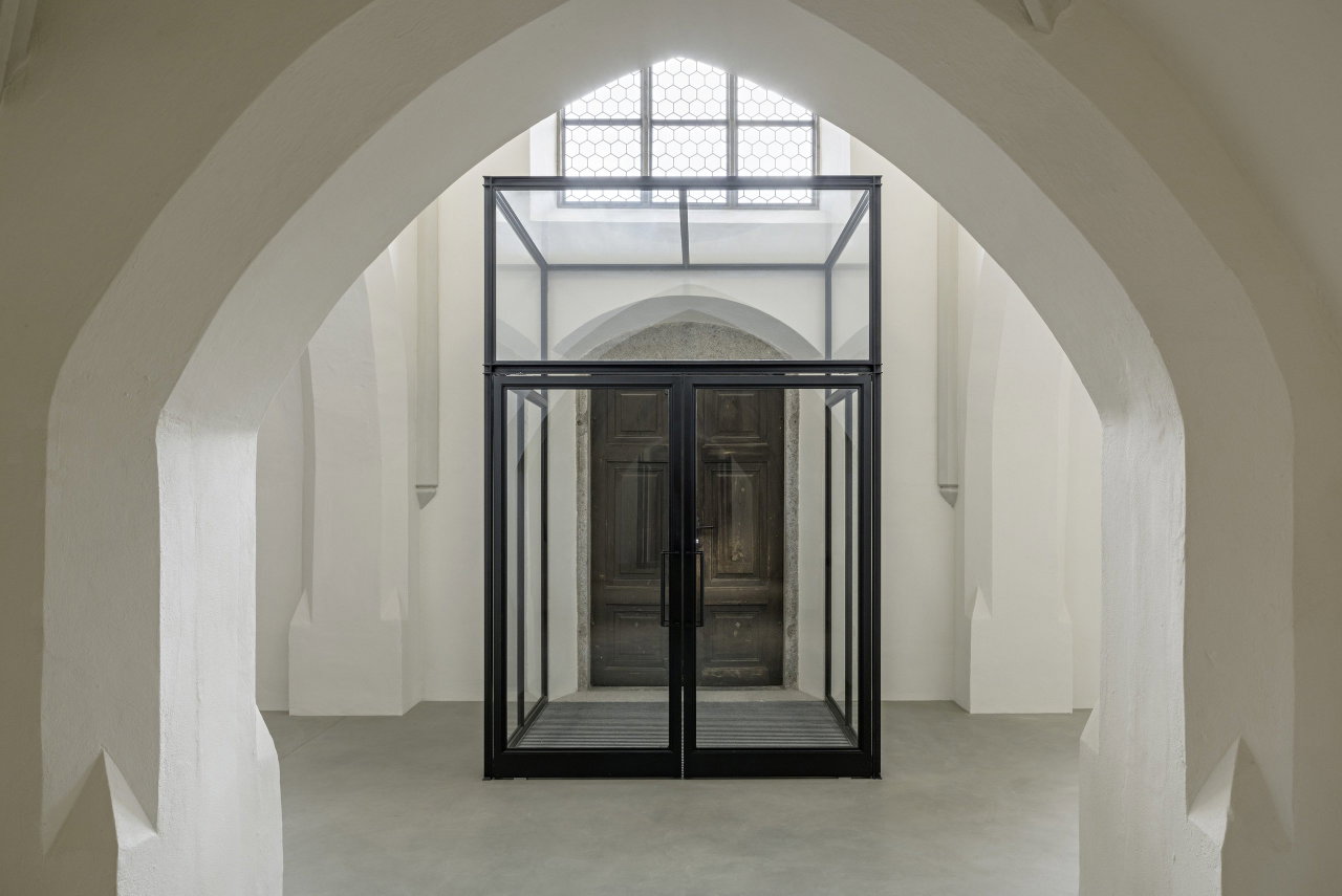 Pivottür aus Stahl und Glas in einem Sakralbau in Oberneukirchen mit FritsJurgens System M Pivot-Scharniersystem im Inneren