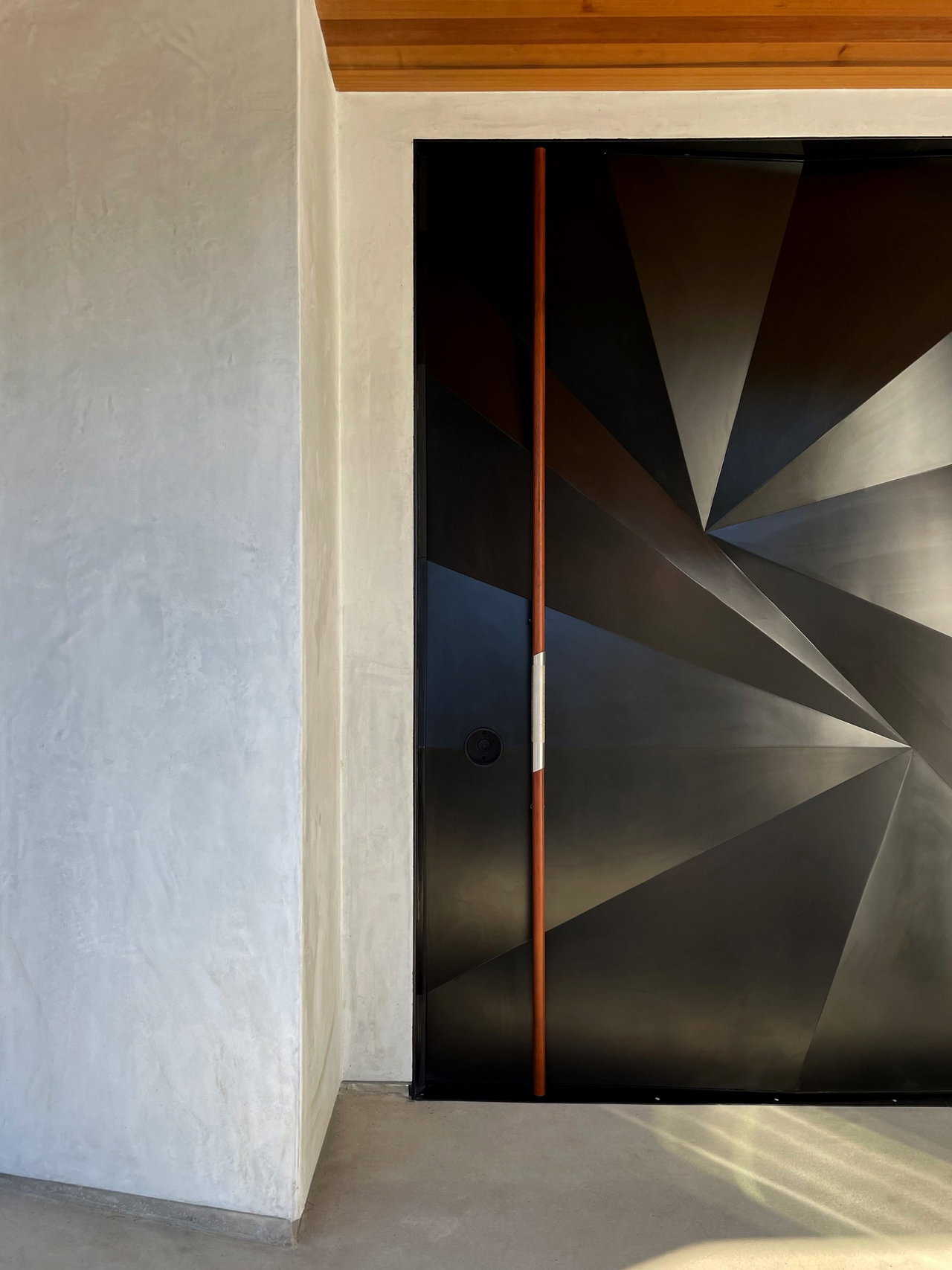 Aluminium pivot door in a private home in San Diego with FritsJurgens System M+ pivot hinge system inside