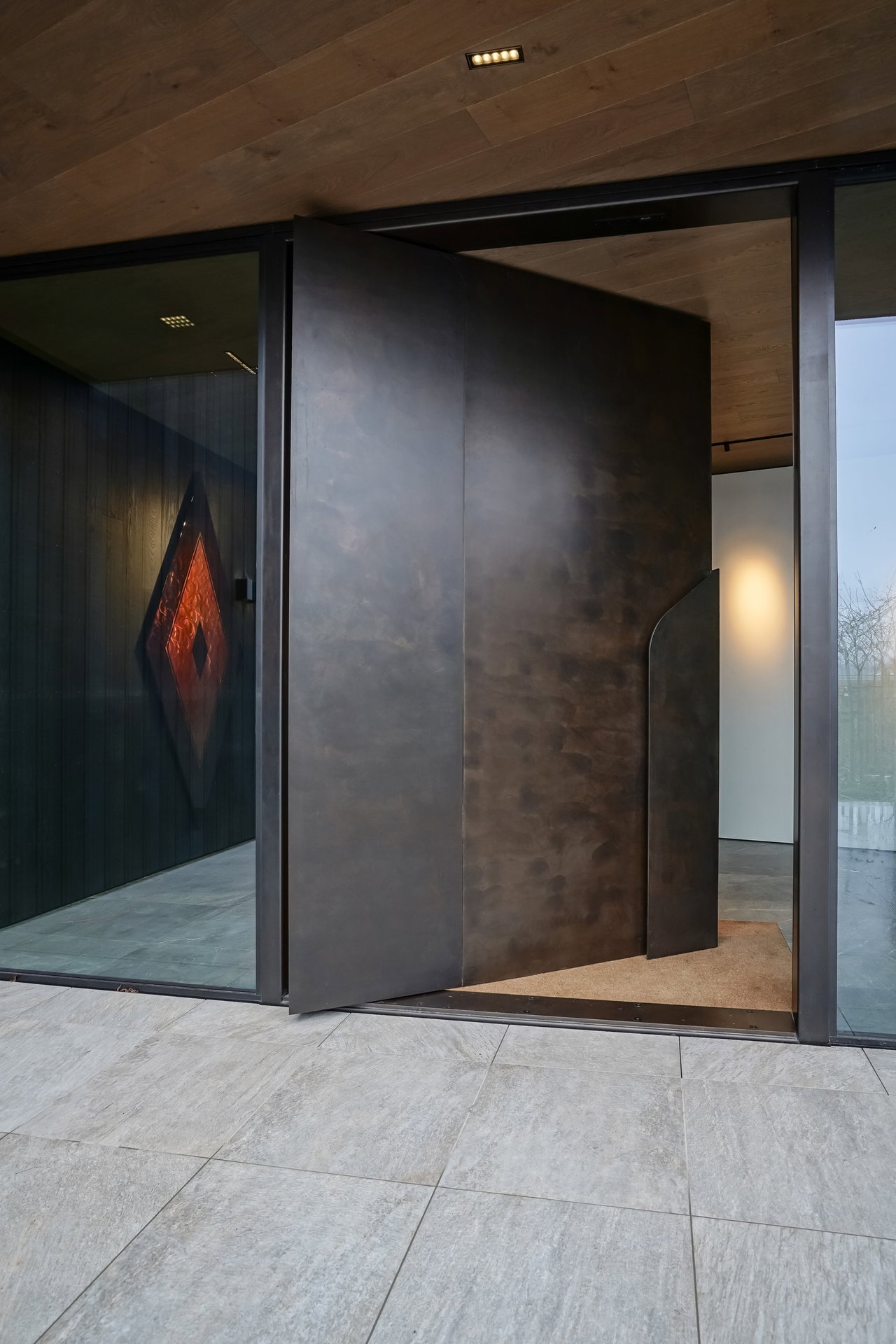 Aluminium pivot door in a private home in Queenstown with FritsJurgens System M pivot hinge system inside