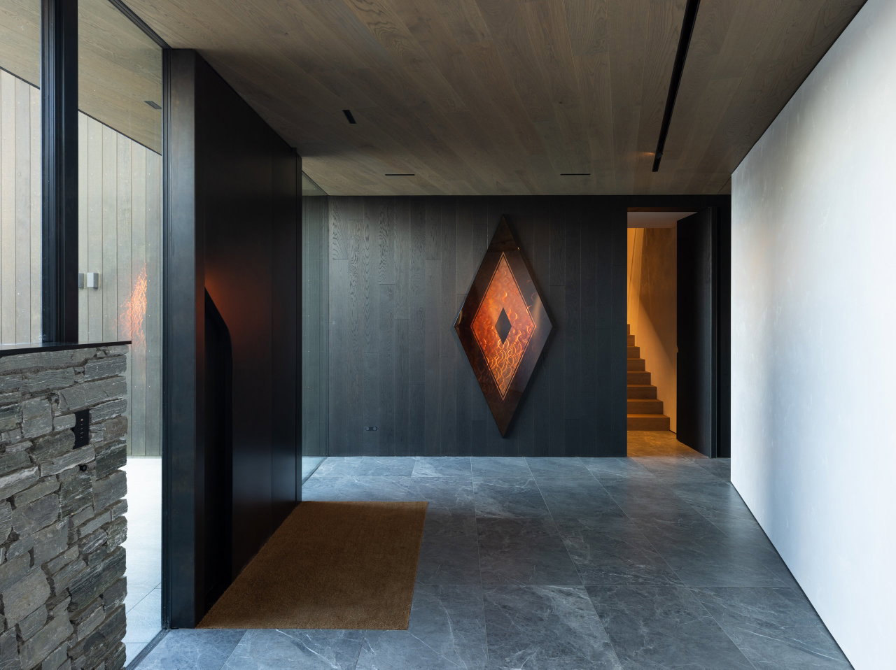 Aluminium pivot door in a private home in Queenstown with FritsJurgens System M pivot hinge system inside