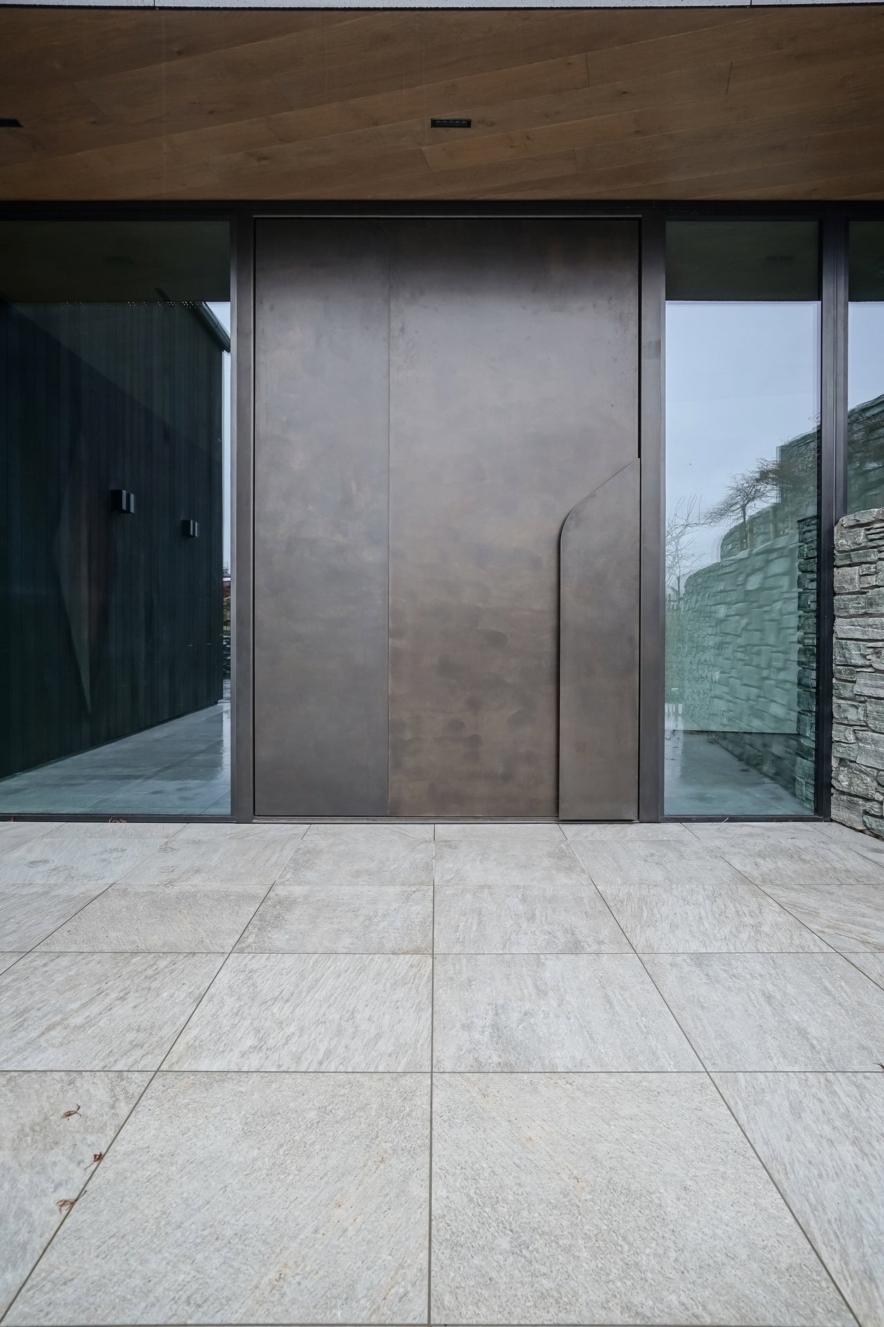 Aluminium pivot door in a private home in Queenstown with FritsJurgens System M pivot hinge system inside