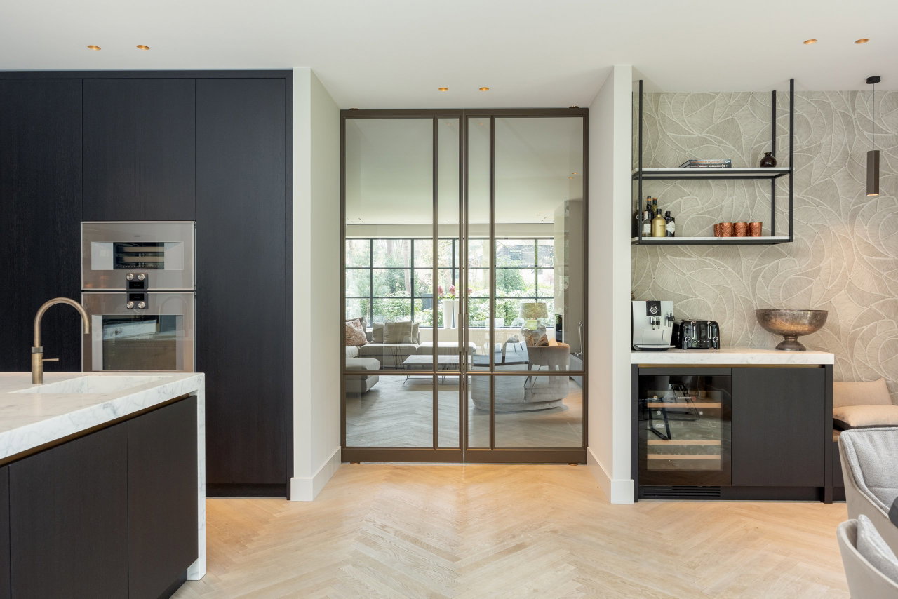 Steel and glass pivot door in a private home in Bilthoven with FritsJurgens System M pivot hinge system inside
