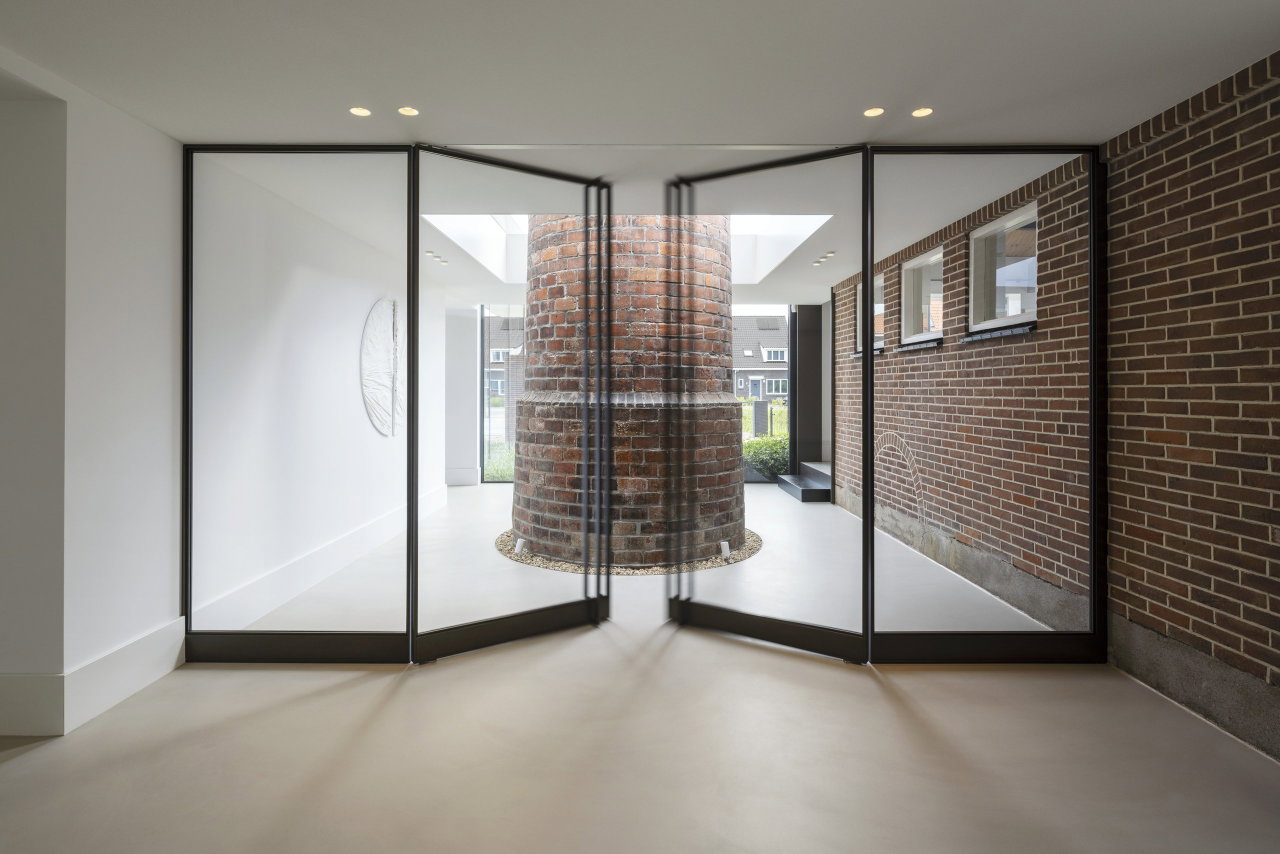 Steel and glass pivot door in an office in Aalsmeer with FritsJurgens System M+ pivot hinge system inside