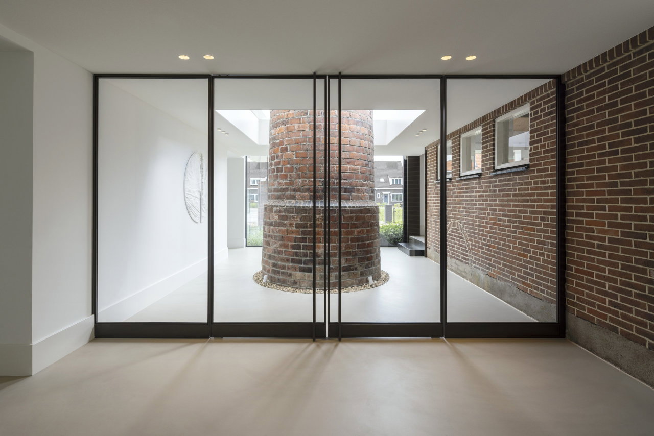 Steel and glass pivot door in an office in Aalsmeer with FritsJurgens System M+ pivot hinge system inside