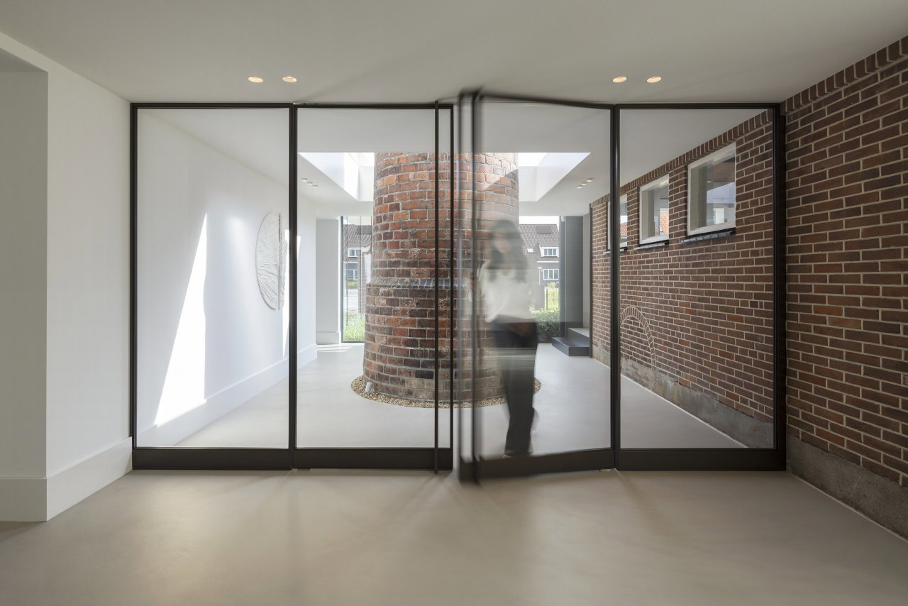 Steel and glass pivot door in an office in Aalsmeer with FritsJurgens System M+ pivot hinge system inside