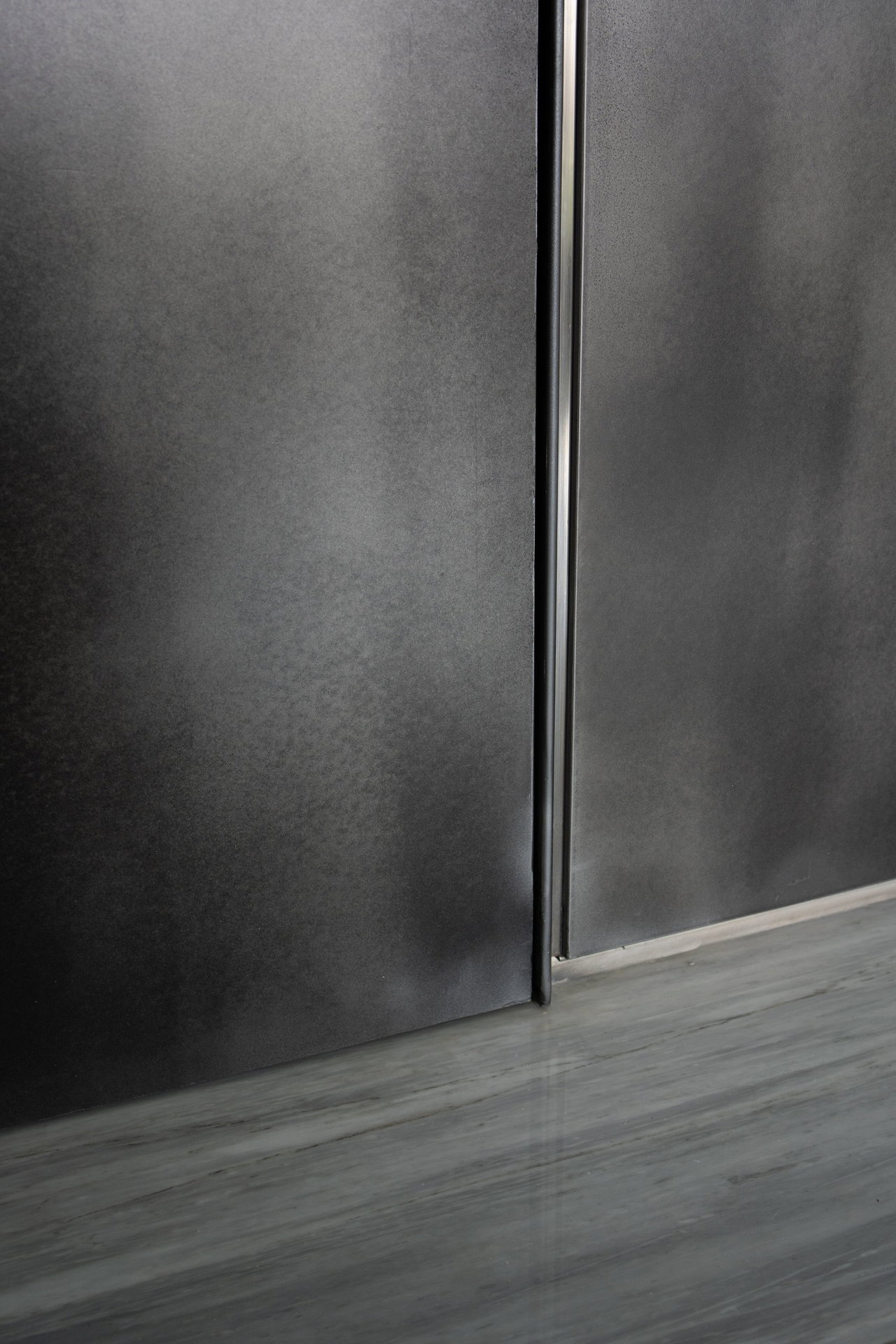 Aluminium pivot door in a private home in Jakarta with FritsJurgens System M+ pivot hinge system inside