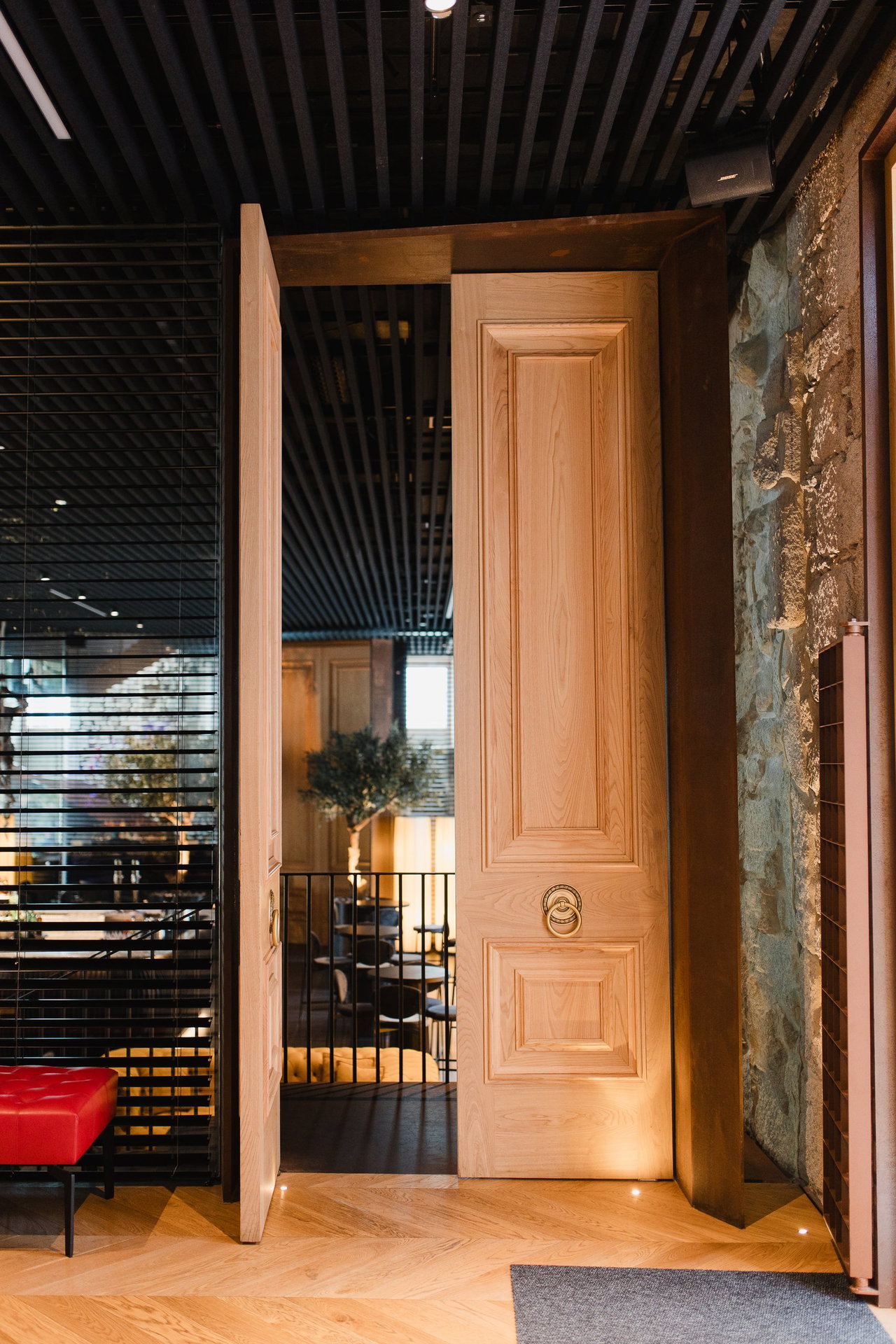 Pivottür aus Holz in einem Restaurant in Vigo mit FritsJurgens System M+ Pivot-Scharniersystem im Inneren