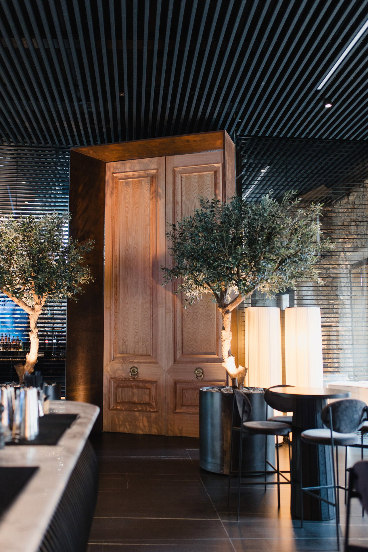 Pivottür aus Holz in einem Restaurant in Vigo mit FritsJurgens System M+ Pivot-Scharniersystem im Inneren