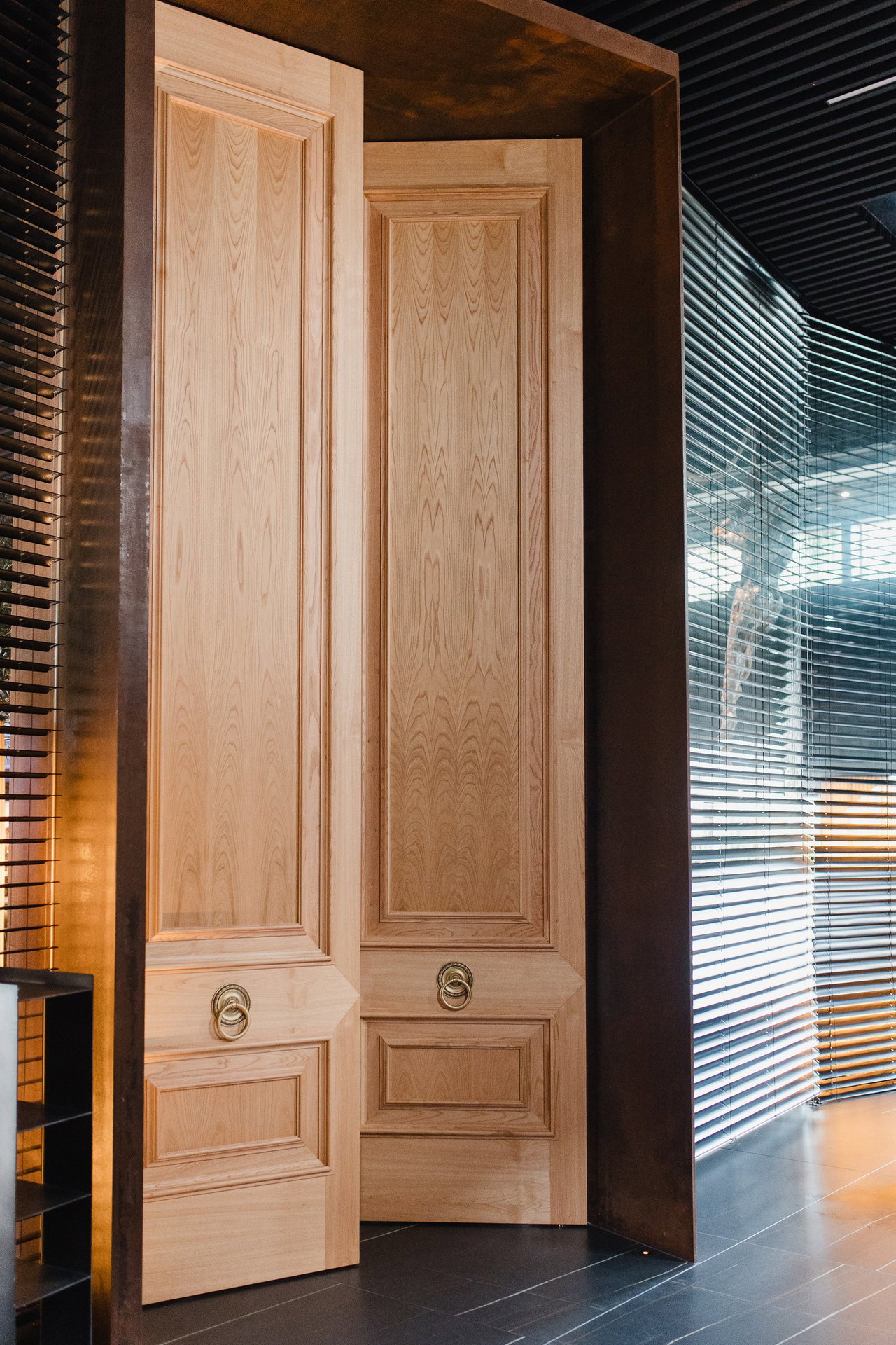 Pivottür aus Holz in einem Restaurant in Vigo mit FritsJurgens System M+ Pivot-Scharniersystem im Inneren