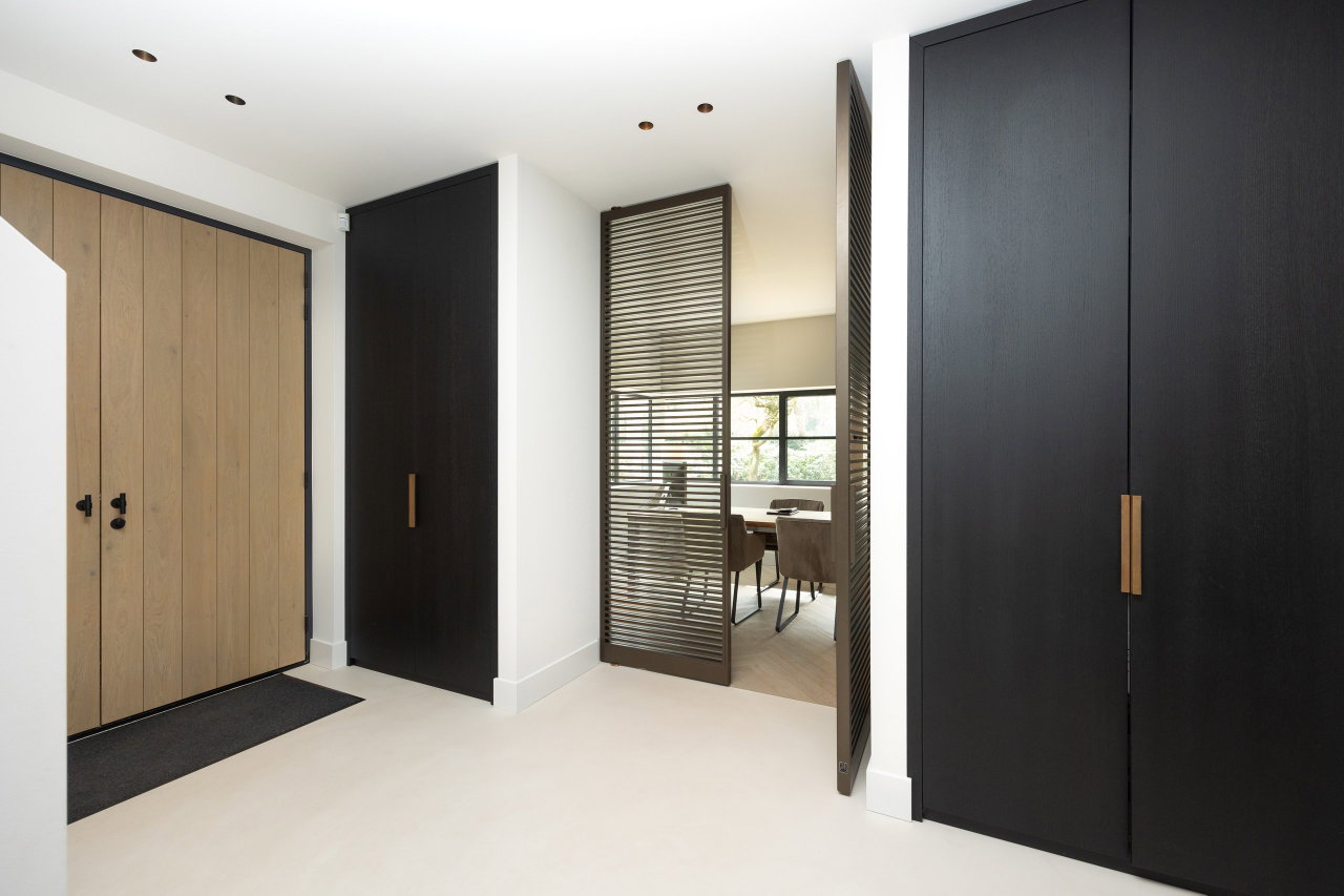 Steel and glass pivot door in a private home in Bilthoven with FritsJurgens System M pivot hinge system inside