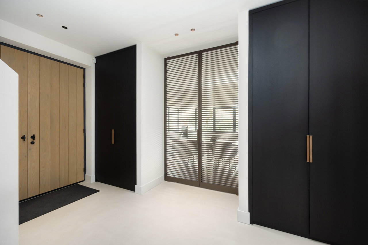 Steel and glass pivot door in a private home in Bilthoven with FritsJurgens System M pivot hinge system inside