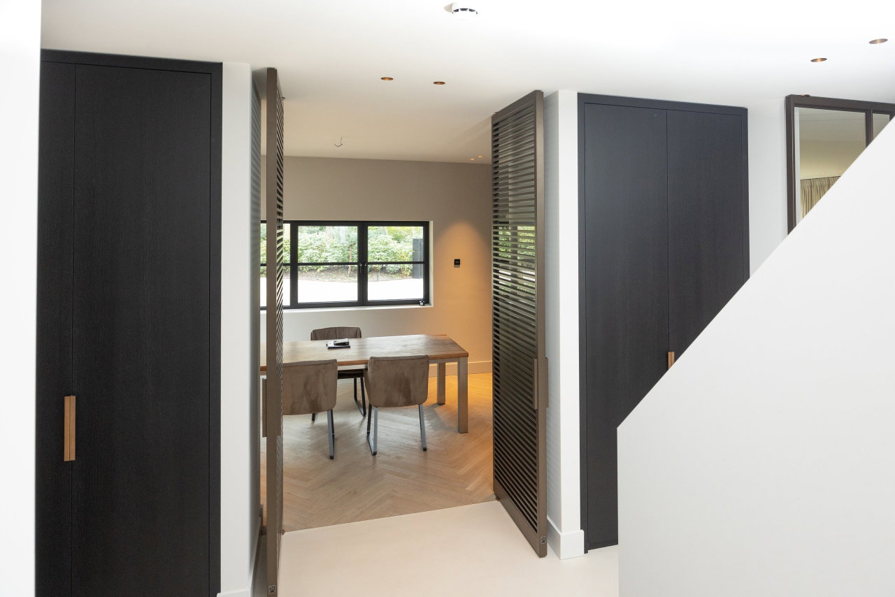Steel and glass pivot door in a private home in Bilthoven with FritsJurgens System M pivot hinge system inside