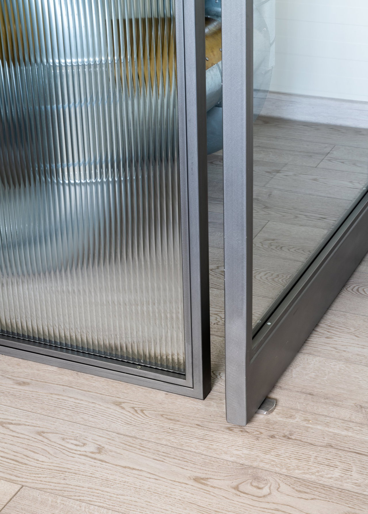 Pivottür aus Stahl und Glas in einem Büro in Vilnius mit FritsJurgens System M+ Pivot-Scharniersystem im Inneren