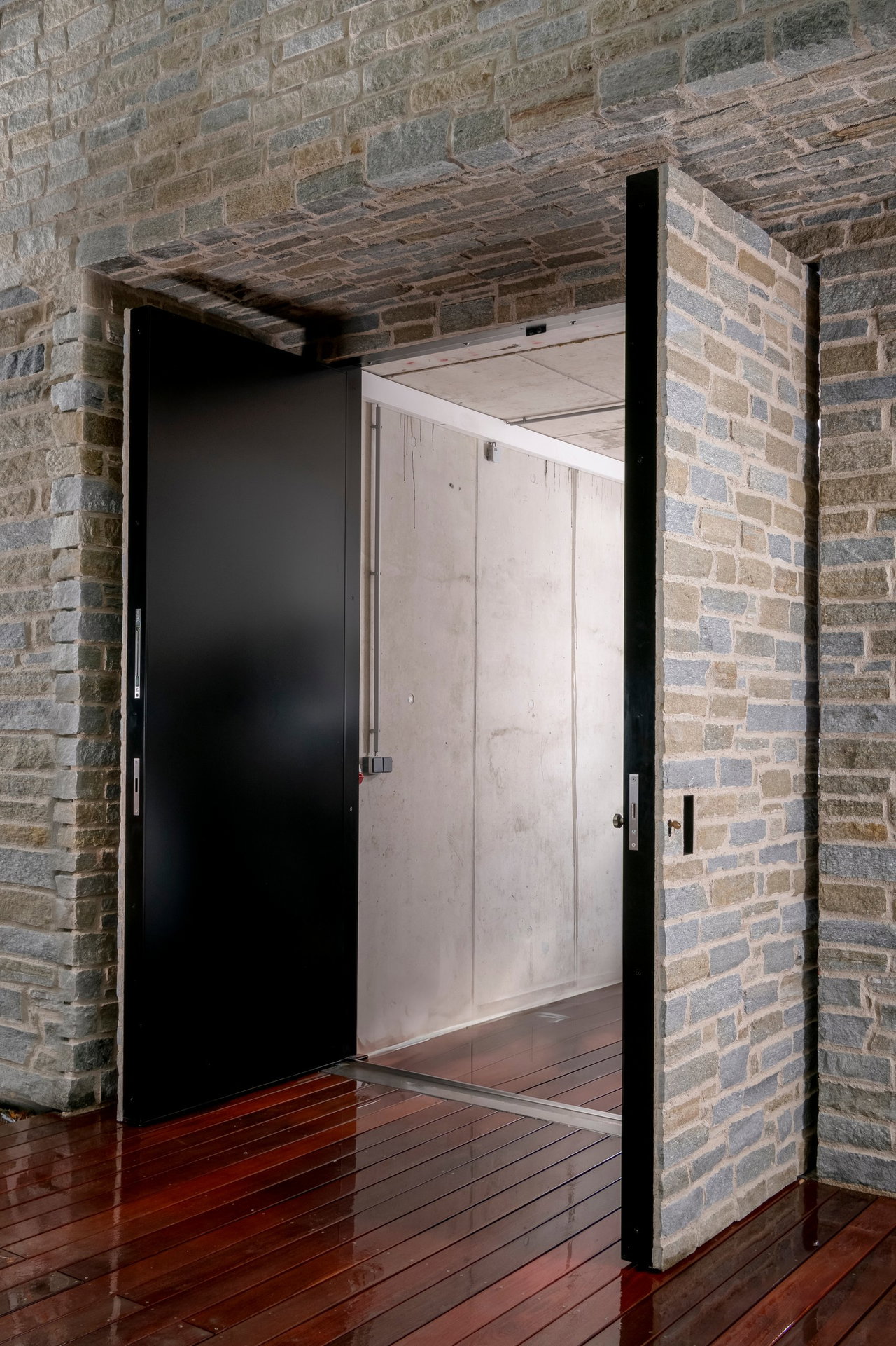 Stone pivot door in a private home in Kitzbühel with FritsJurgens System M+ pivot hinge system inside