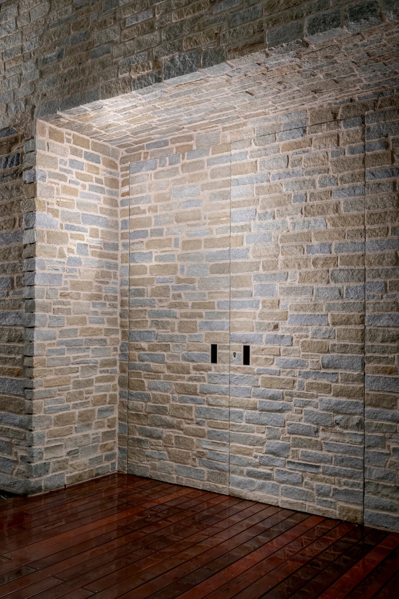 Stone pivot door in a private home in Kitzbühel with FritsJurgens System M+ pivot hinge system inside