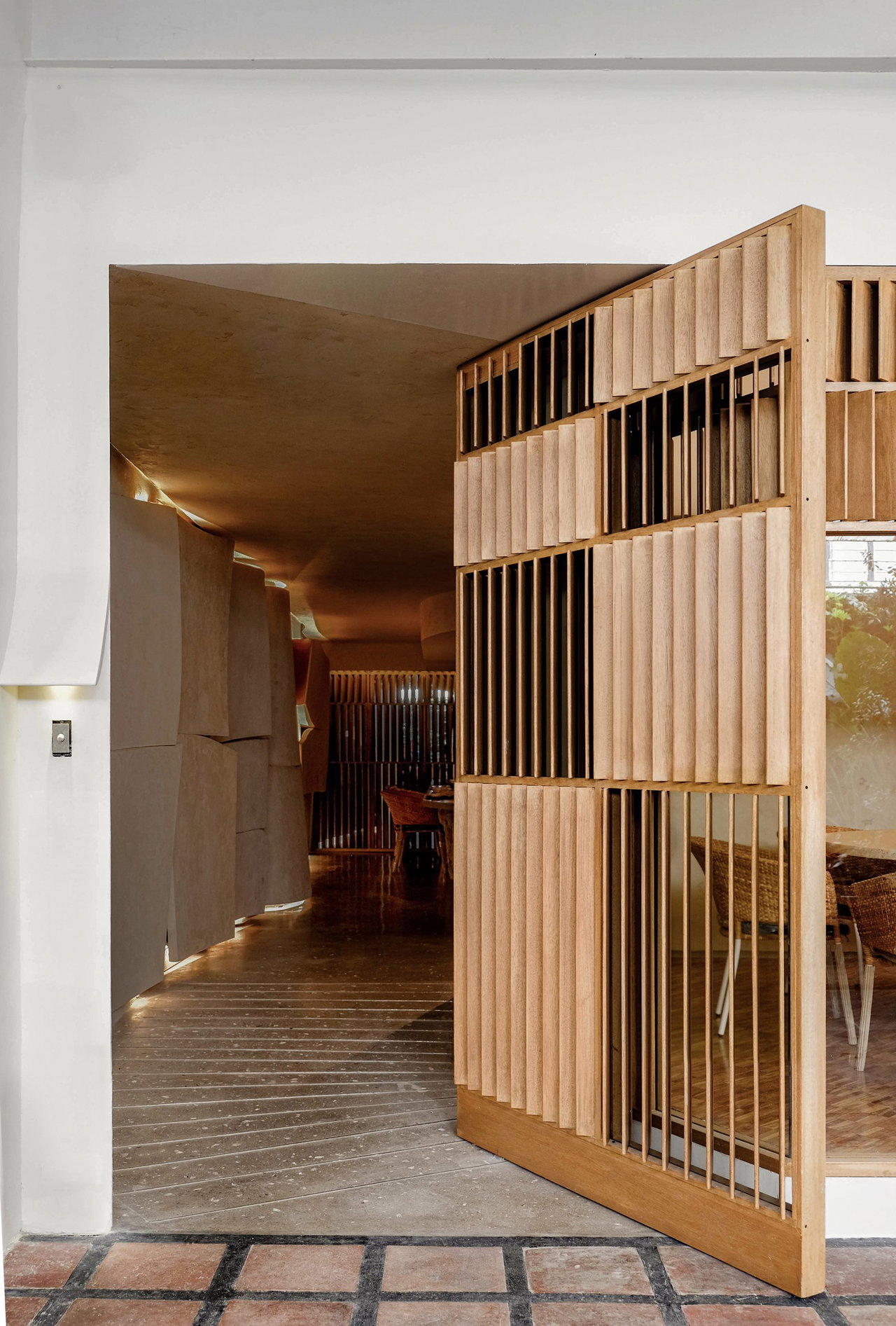 Wooden pivot door in a restaurant in Makati City with FritsJurgens System M+ pivot hinge system inside