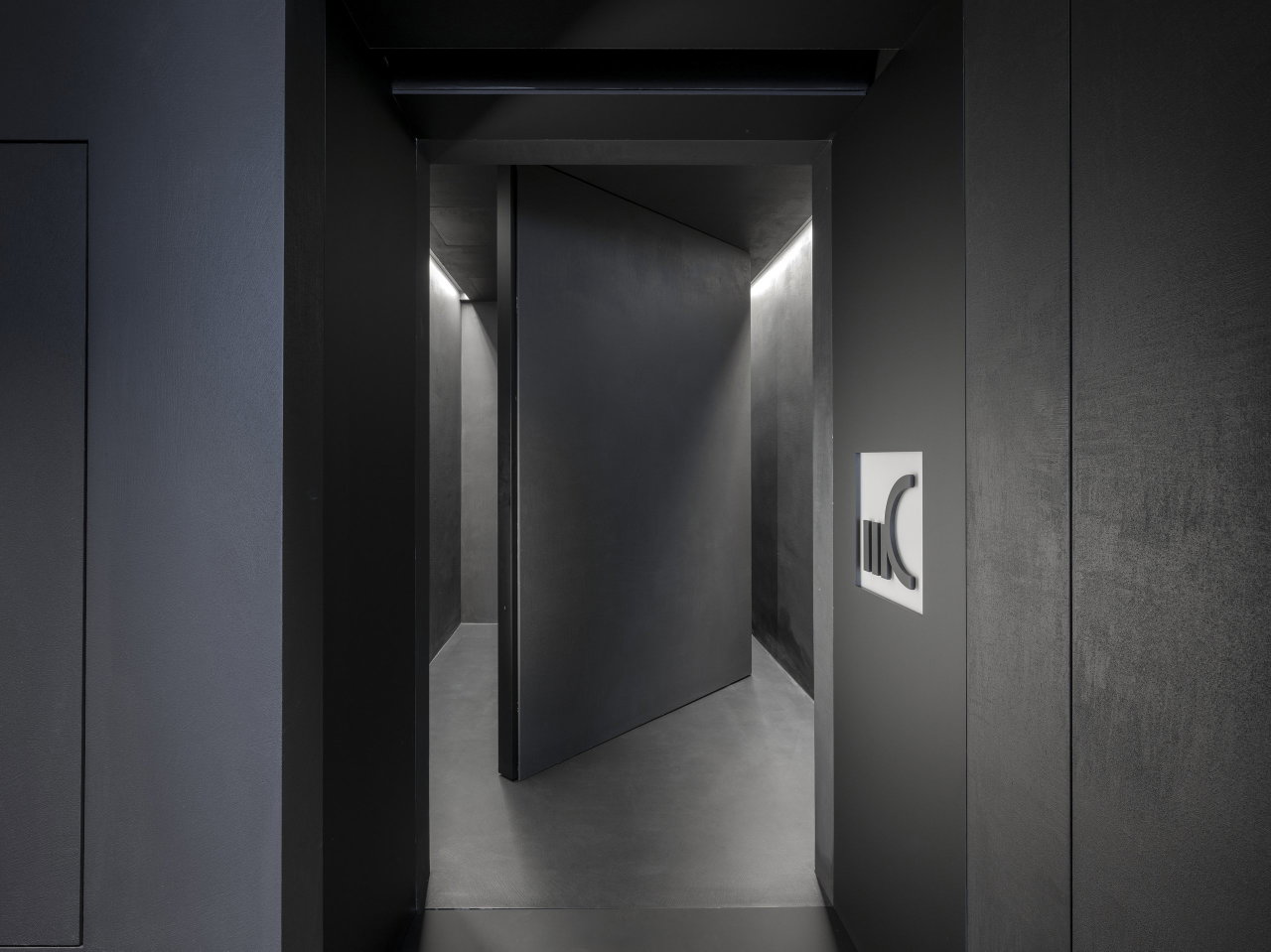 Stone pivot door in an office in Milan with FritsJurgens System M+ pivot hinge system inside