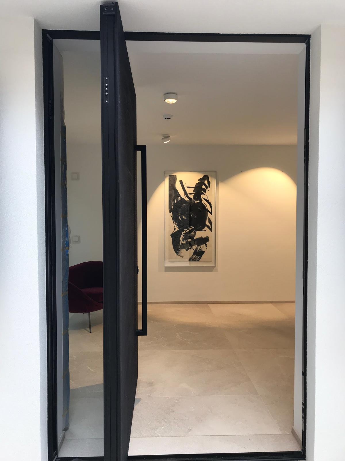 Aluminium pivot door in a private home in Santa Ponça with FritsJurgens System M pivot hinge system inside