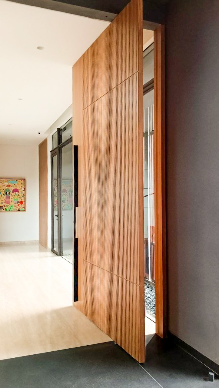 Wooden pivot door in a private home in Jakarta with FritsJurgens System M+ pivot hinge system inside