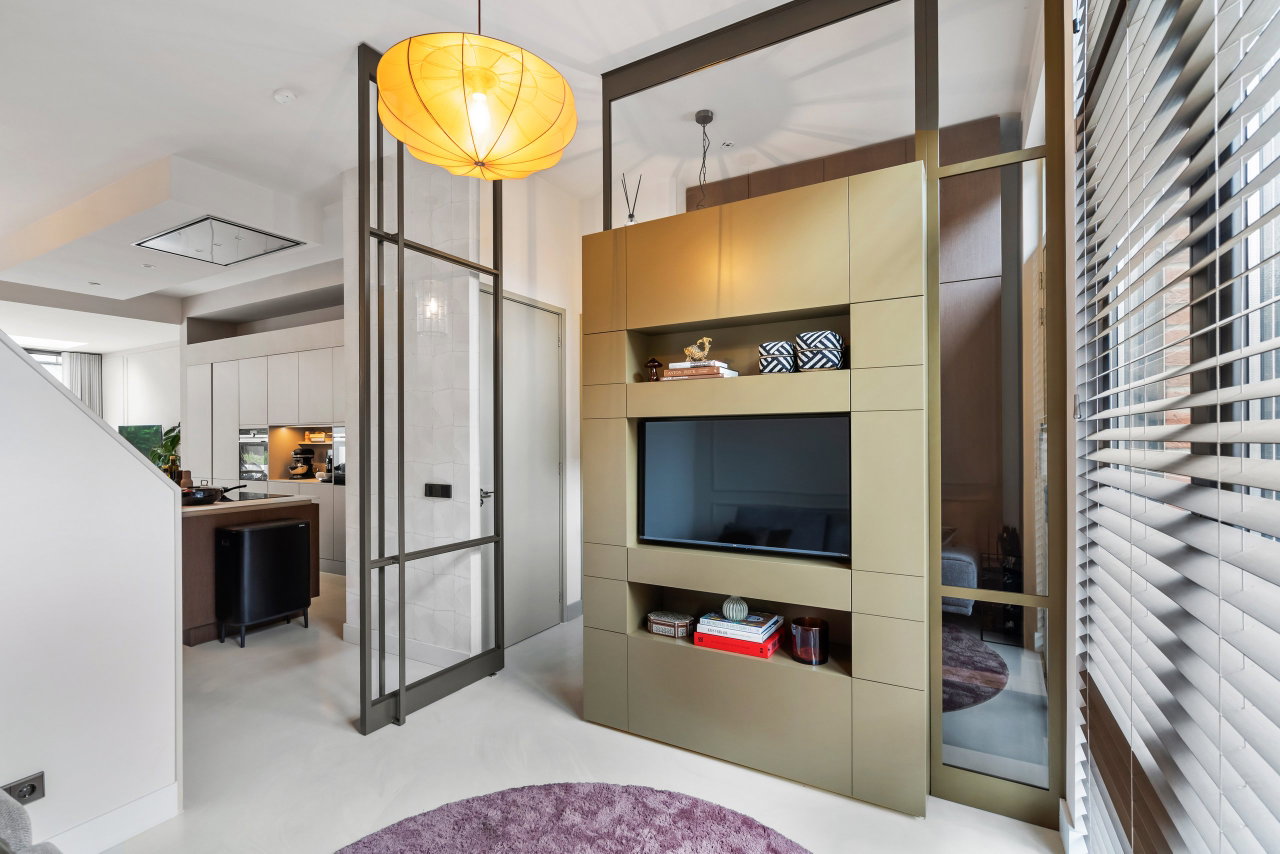 Steel and glass pivot door in a private home in Amsterdam with FritsJurgens System M pivot hinge system inside