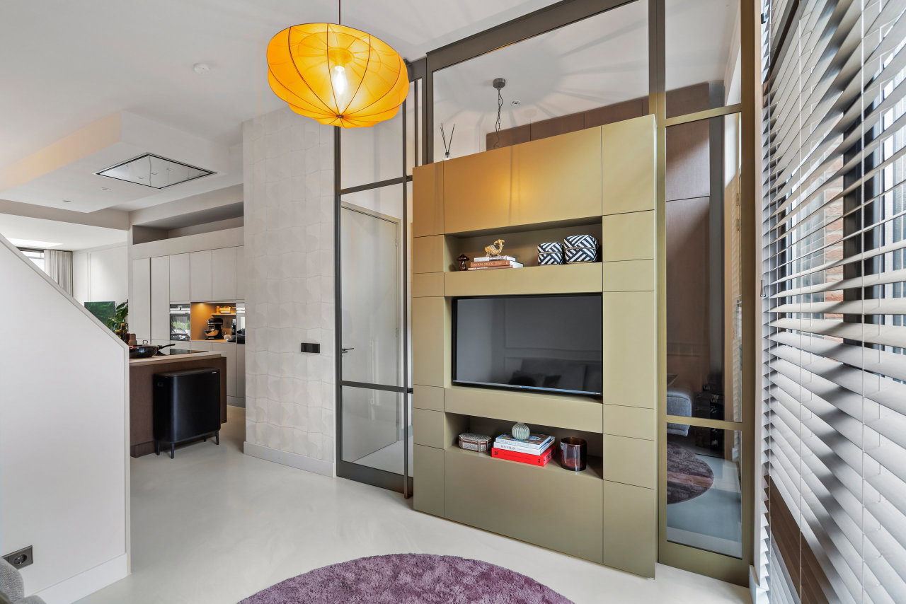 Steel and glass pivot door in a private home in Amsterdam with FritsJurgens System M pivot hinge system inside
