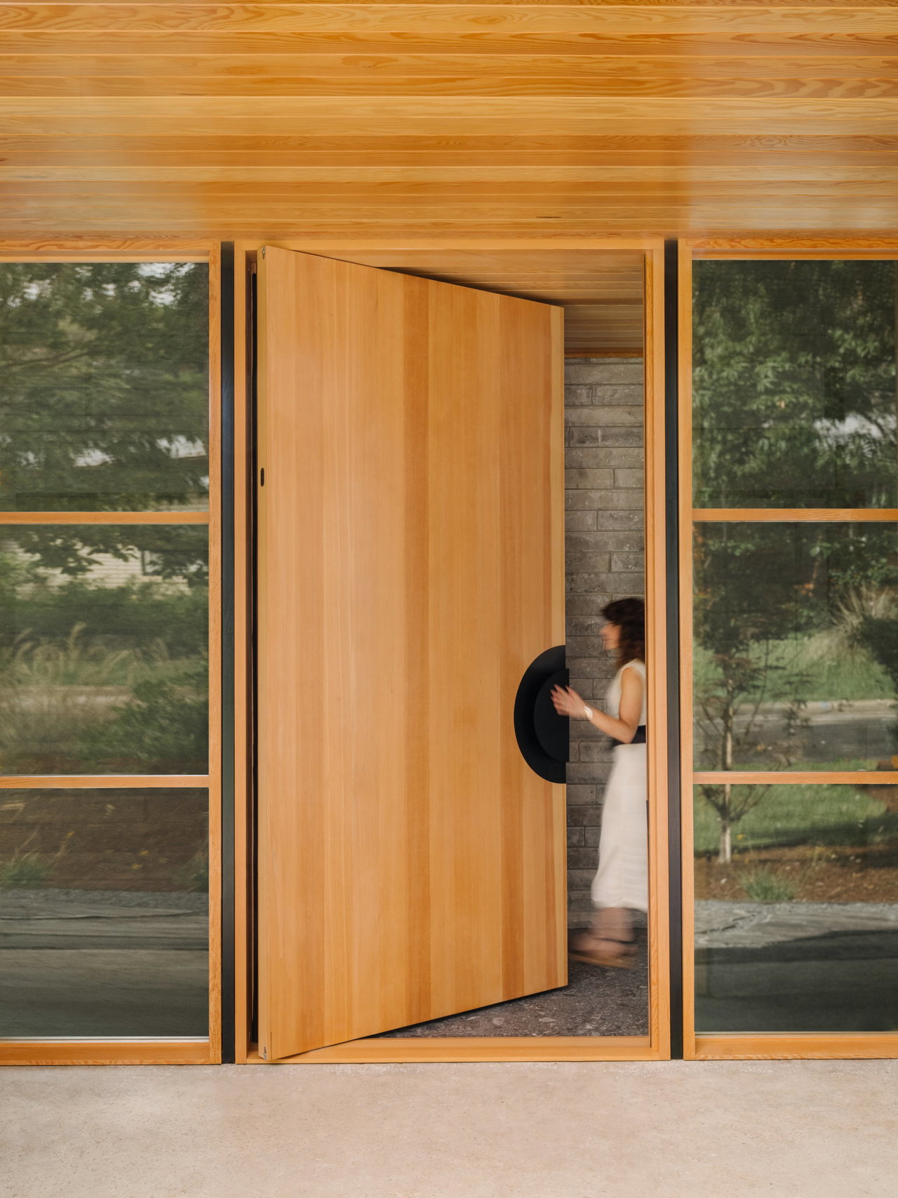 Wooden pivot door in a private home in Austin with FritsJurgens System M+ pivot hinge system inside