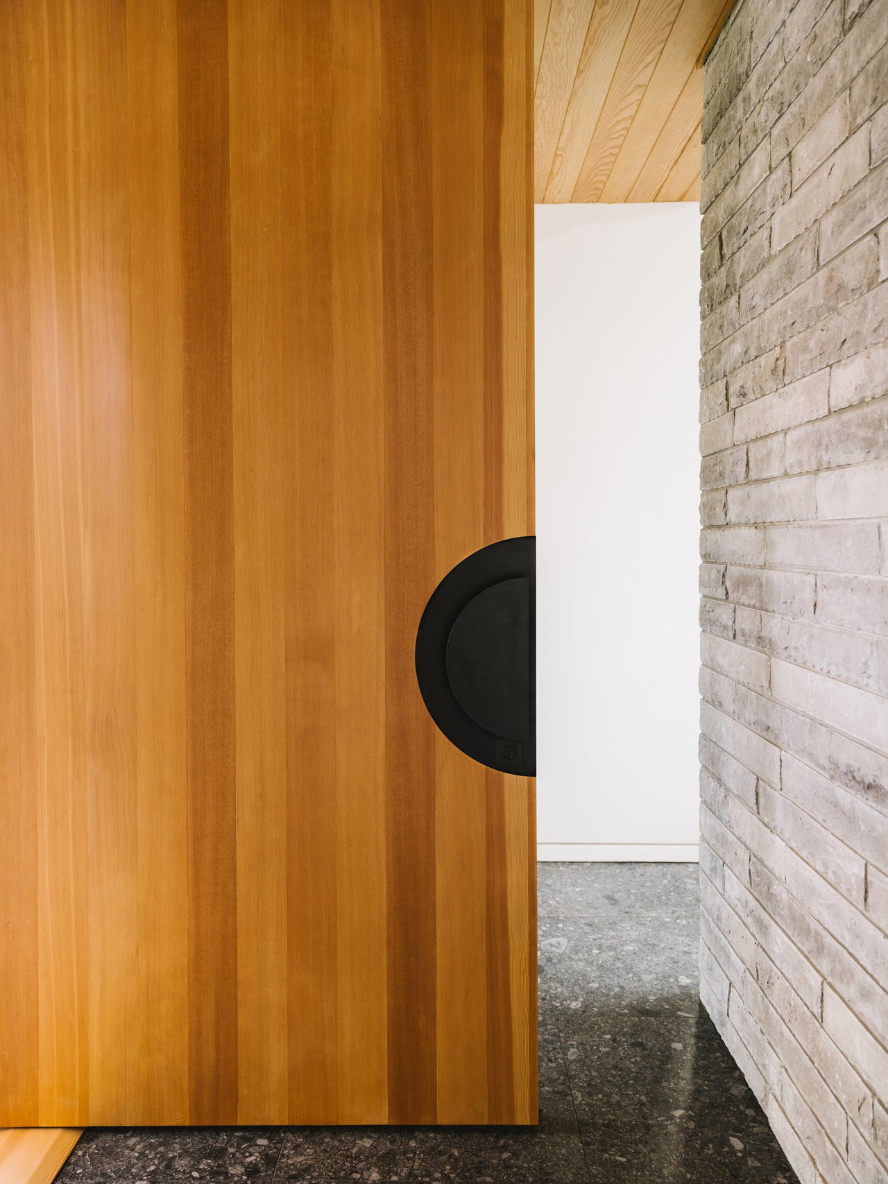 Wooden pivot door in a private home in Austin with FritsJurgens System M+ pivot hinge system inside