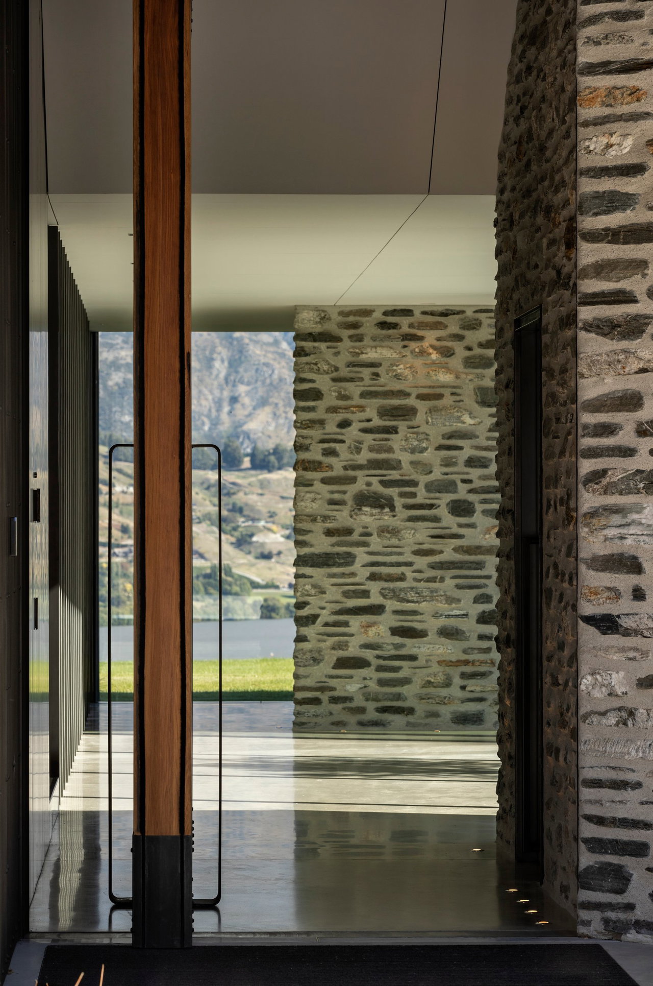 Wooden pivot door in a private home in Queenstown with FritsJurgens System M+ pivot hinge system inside