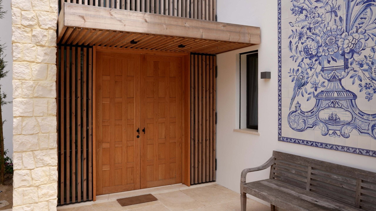 Puerta pivotante de madera en una casa privada en Cascais con bisagra pivotante FritsJurgens System One en el interior