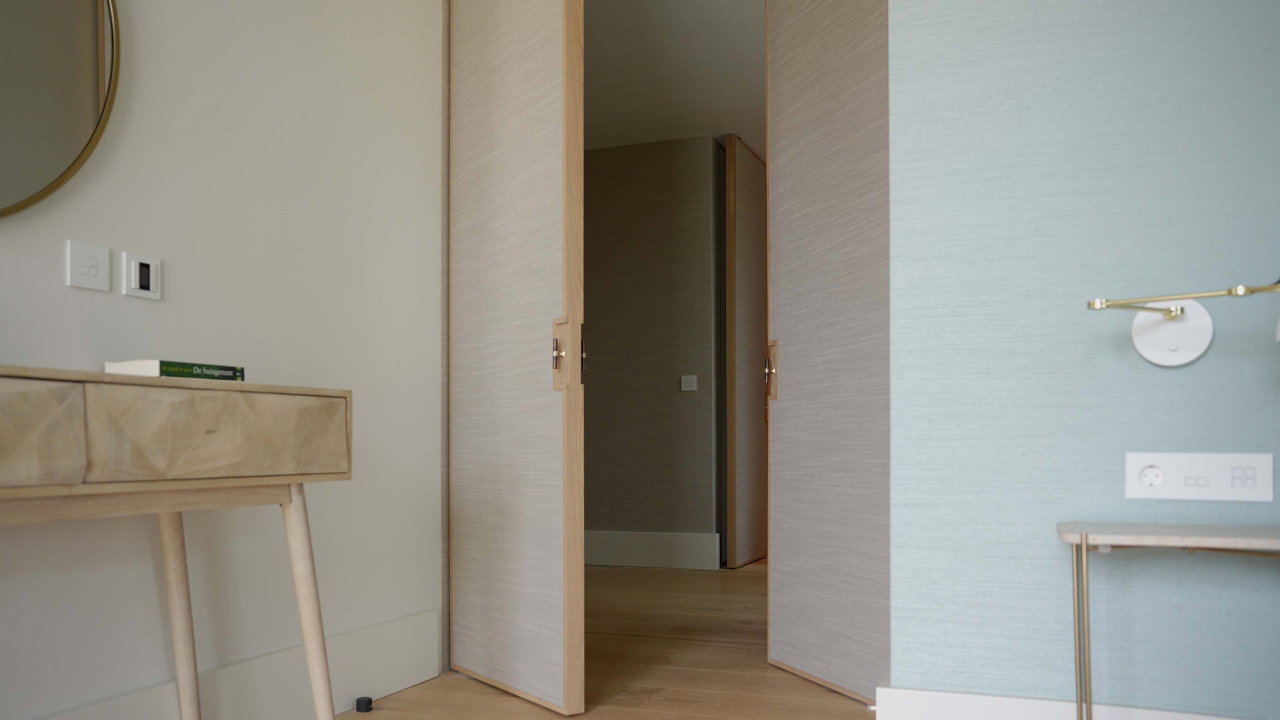 Puerta pivotante de madera en una casa privada en Cascais con bisagra pivotante FritsJurgens System One en el interior