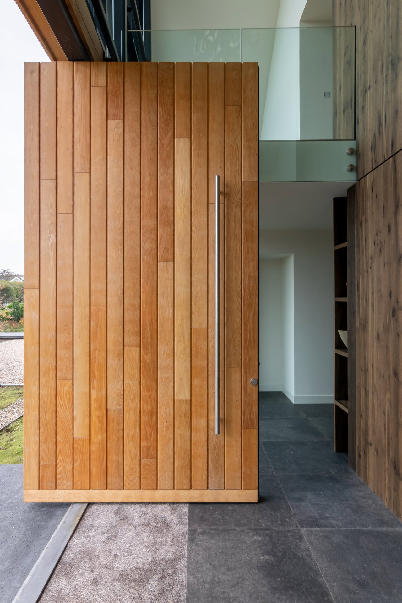 Wooden pivot door in a private home with FritsJurgens System One pivot hinge system inside