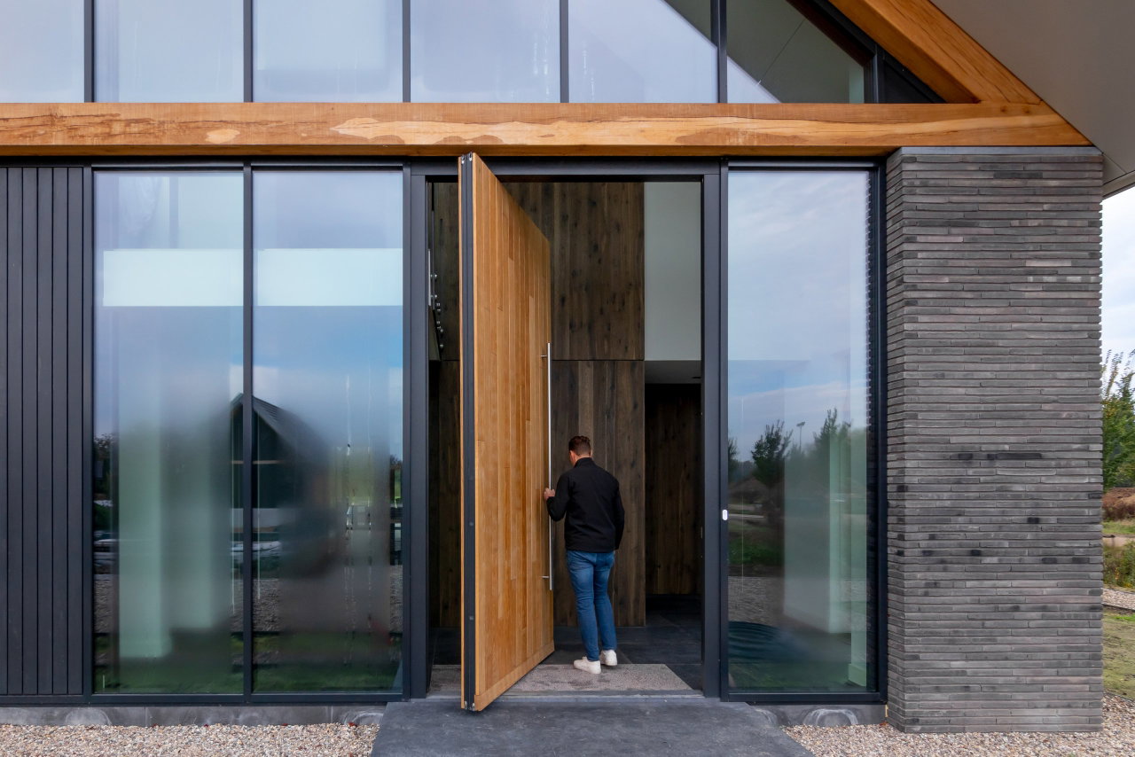 Wooden pivot door in a private home with FritsJurgens System One pivot hinge system inside