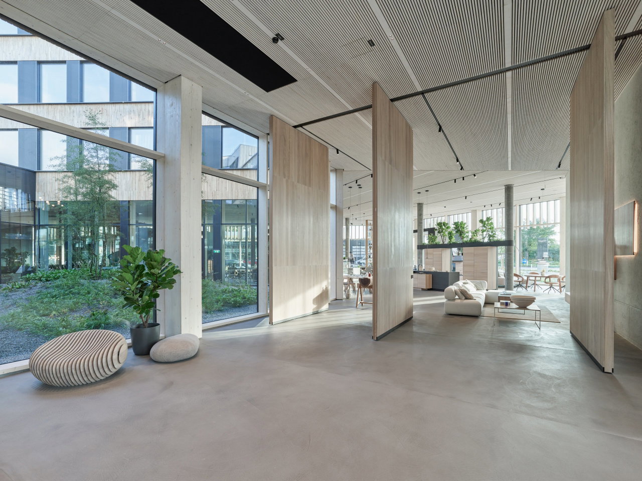 Wooden pivot door in a retail space in Ried im Innkreis with FritsJurgens System M+ pivot hinge system inside