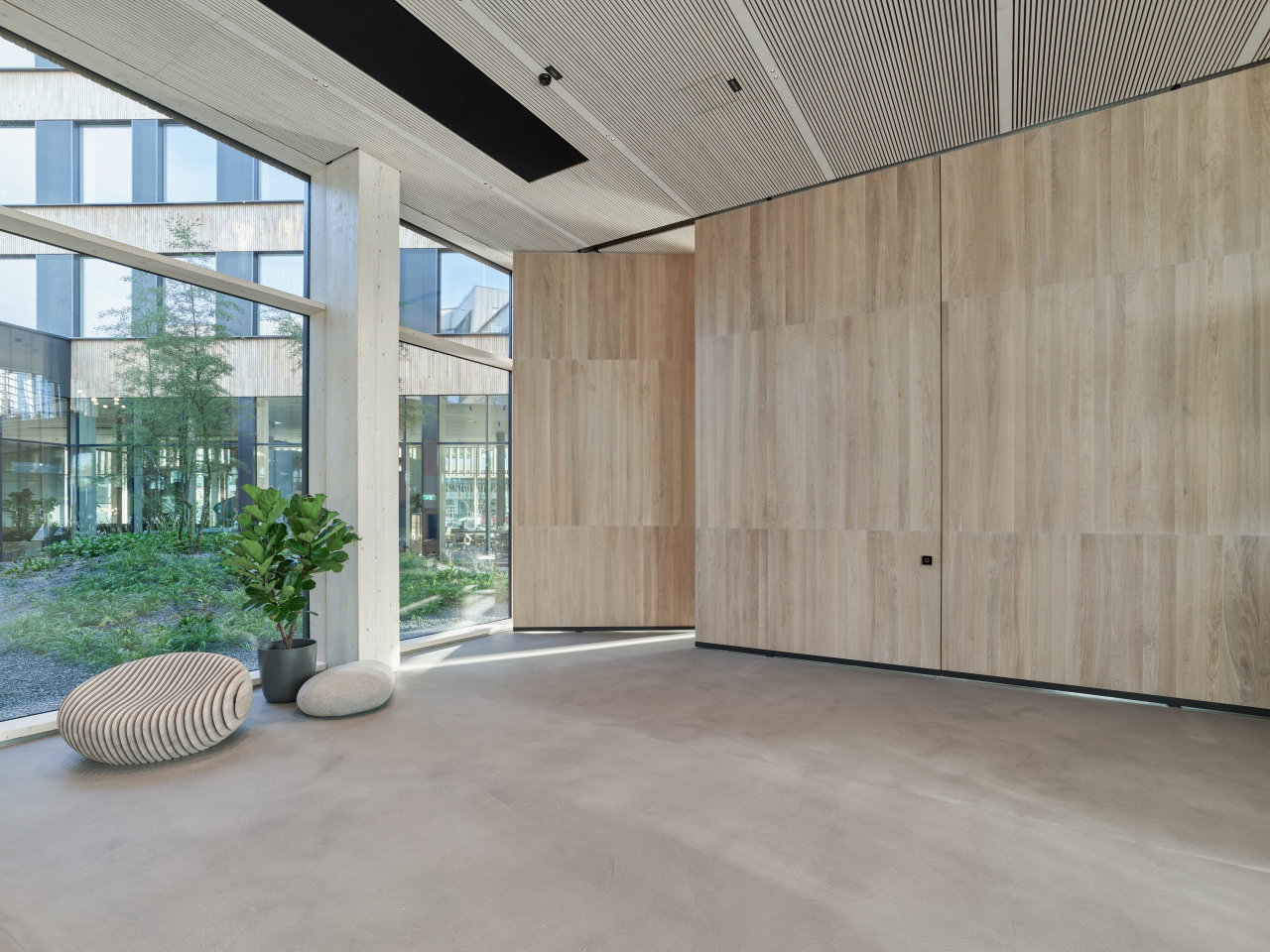 Wooden pivot door in a retail space in Ried im Innkreis with FritsJurgens System M+ pivot hinge system inside