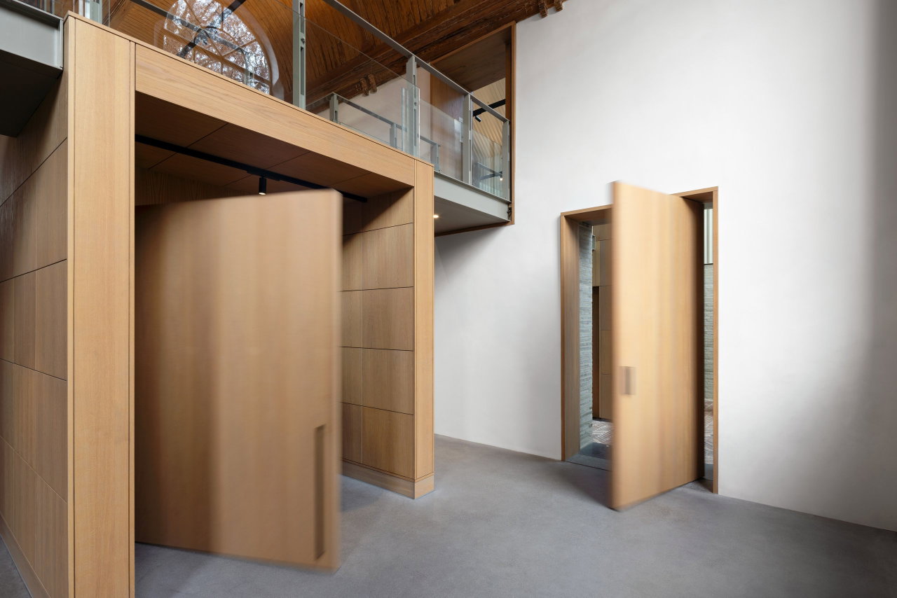 Wooden pivot door in a public building in Dordrecht with FritsJurgens System M+ pivot hinge system inside