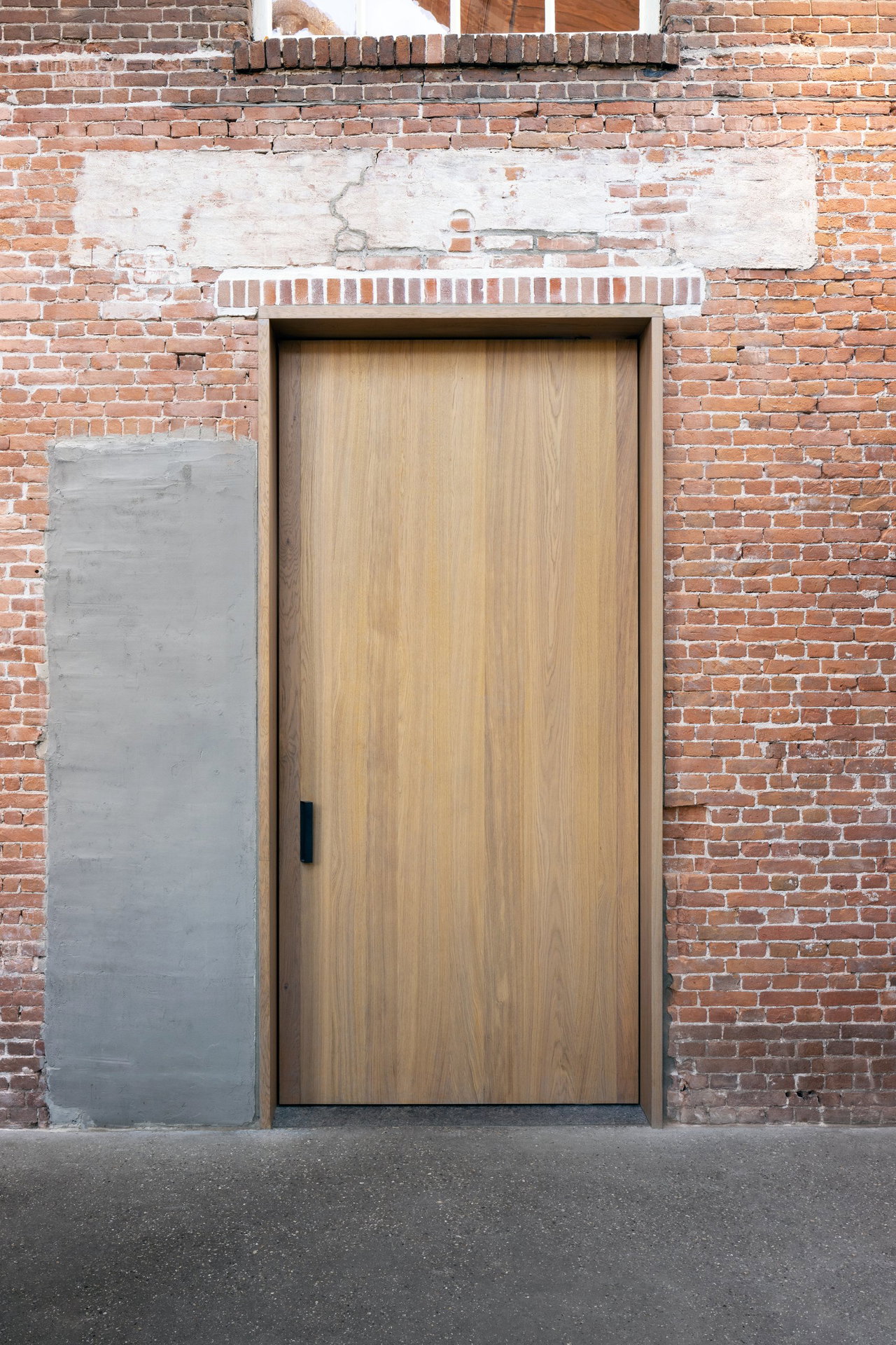 Wooden pivot door in a public building in Dordrecht with FritsJurgens System M+ pivot hinge system inside