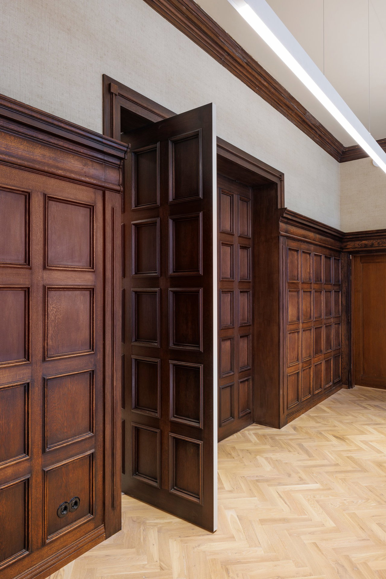 Wooden pivot door in an office in Amsterdam with FritsJurgens System M+ pivot hinge system inside