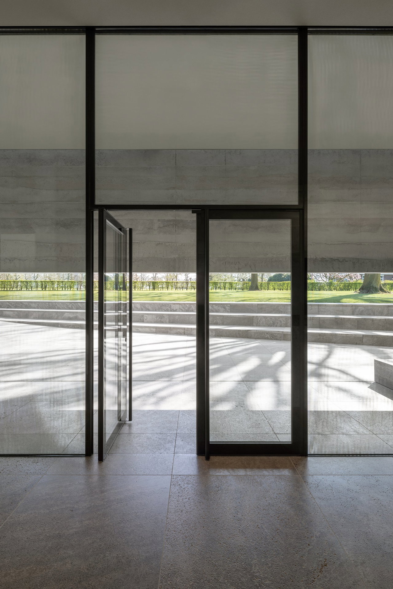 Steel and glass pivot door at a public site in Margraten with FritsJurgens System M+ pivot hinge system inside