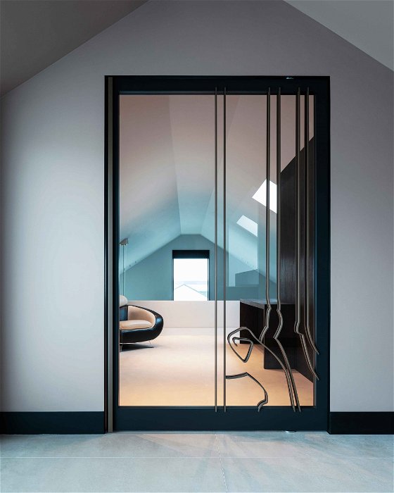 Glass interior pivot door with steel artwork 1