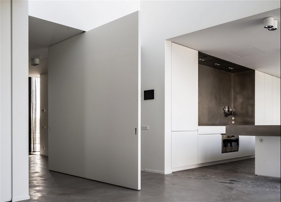 Pivoting oversized door in white with middle placement