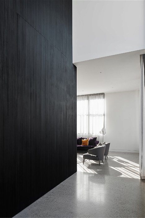 Puerta pivotante de madera negra en una sala de estar– FritsJurgens pivot hinges Inside 2